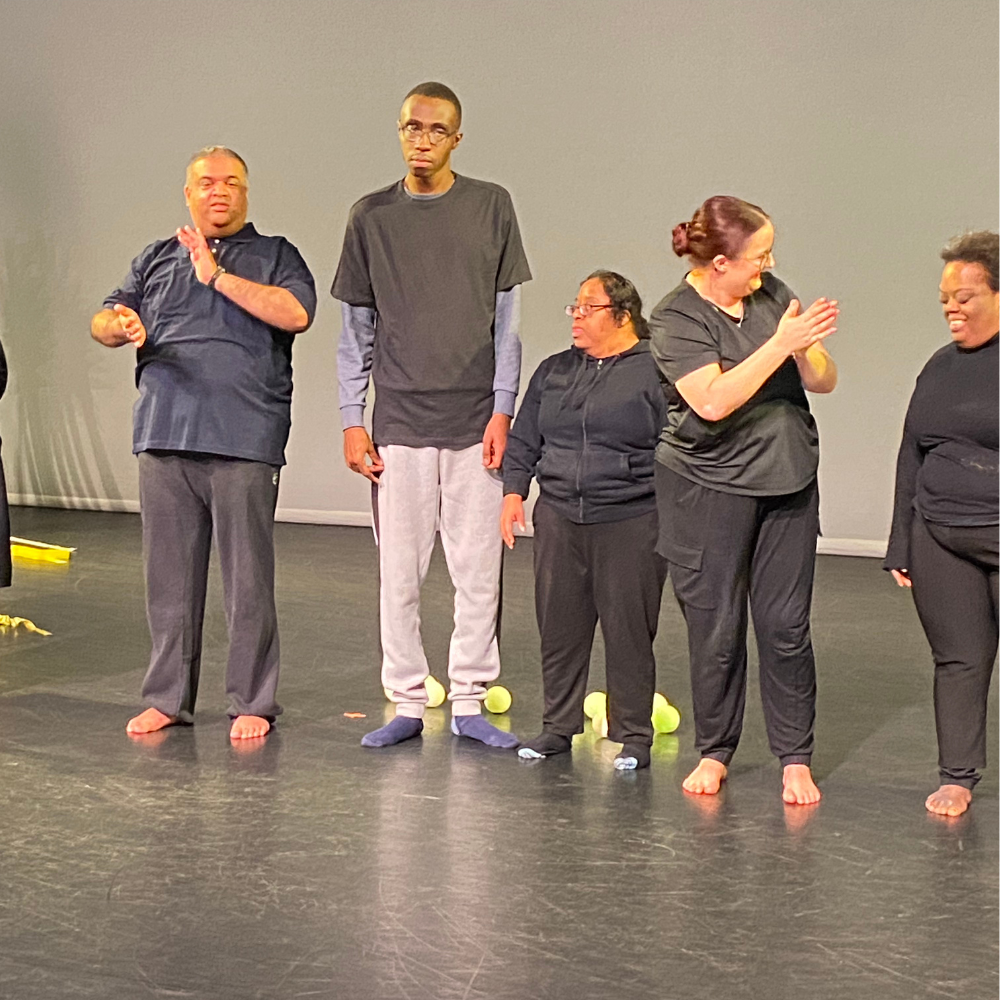 Dancers stand in a row to take a bow at the end