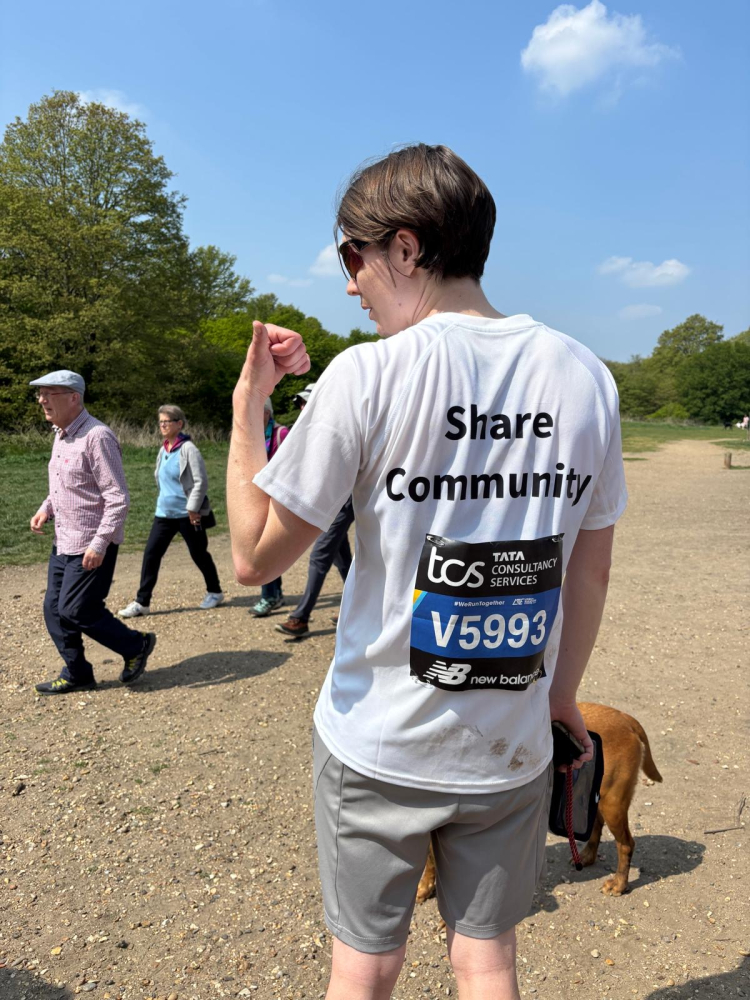 Georgia showing the back of her running shirt with Share logo and race number