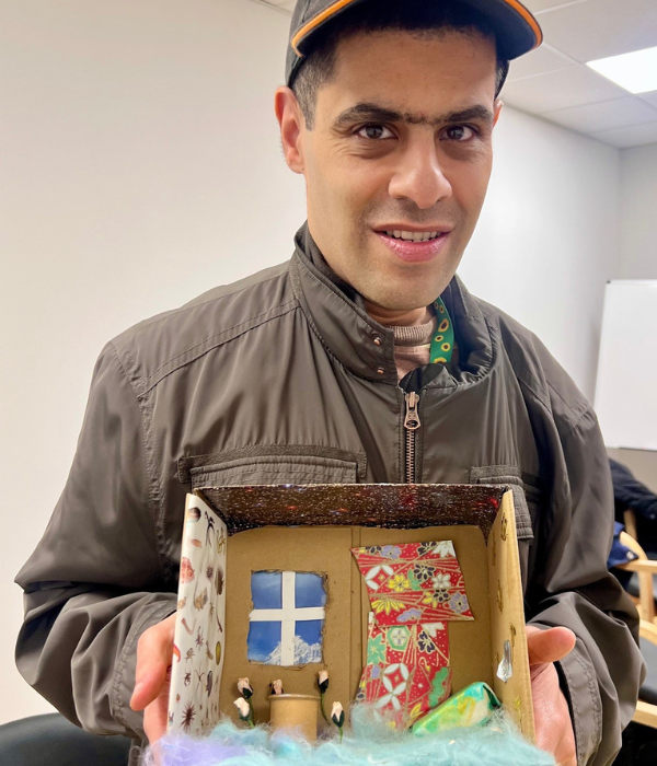 A man proudly holds his shoebox