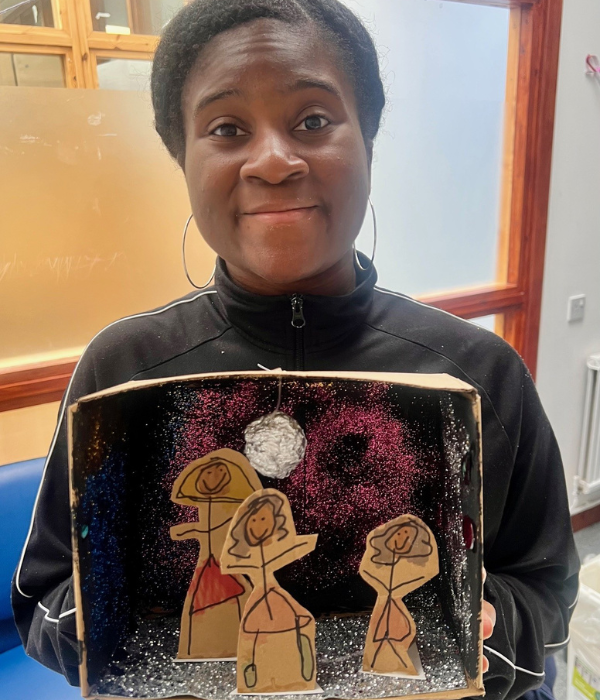 A lady proudly holds her shoebox in front of her