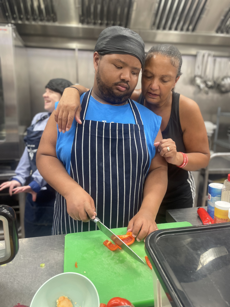 Leon chopping carrots with his mum