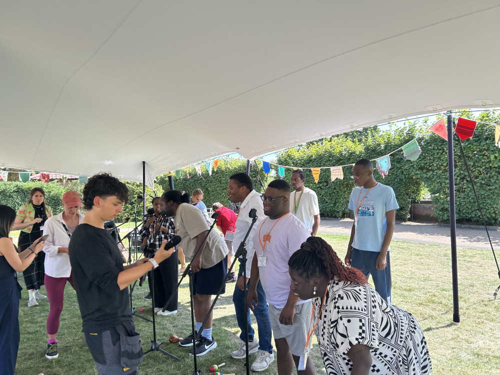 Group under a marquee singing