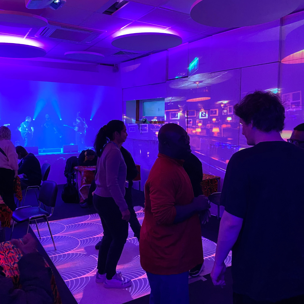 Three people are on a dance floor in a room dimly lit with blues and purples to recreate the jazz club.