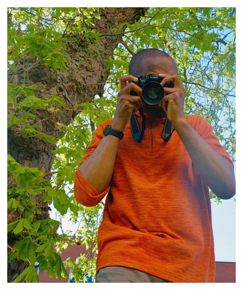 Close up of someone in an orange top taking a photo