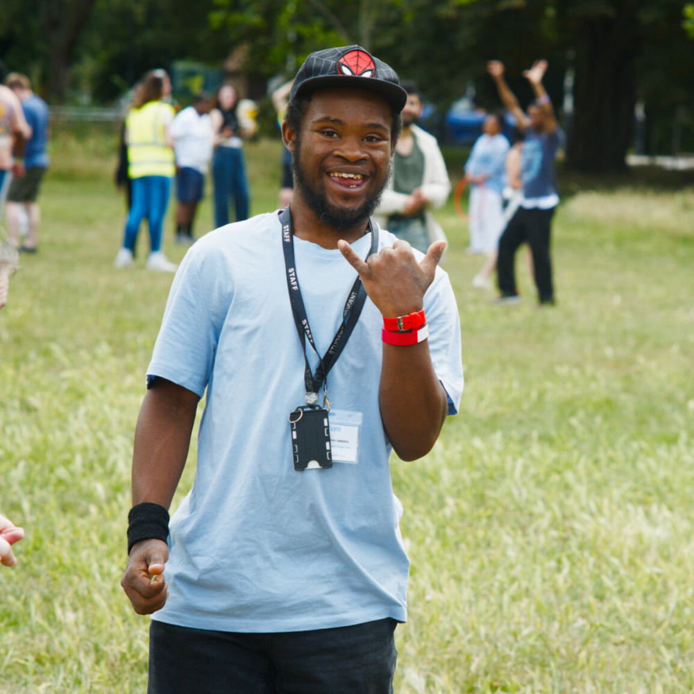 A student in the park does a 'safe' sign with his hand