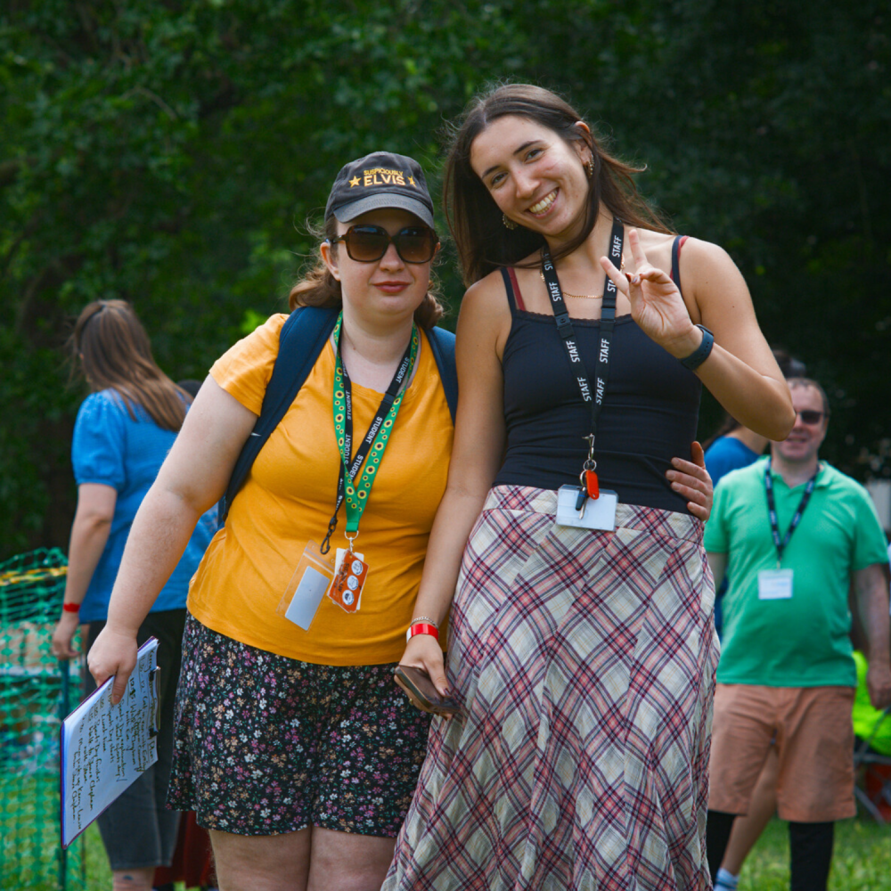 A Share student stands next to a staff member in the park as they pose for a photo
