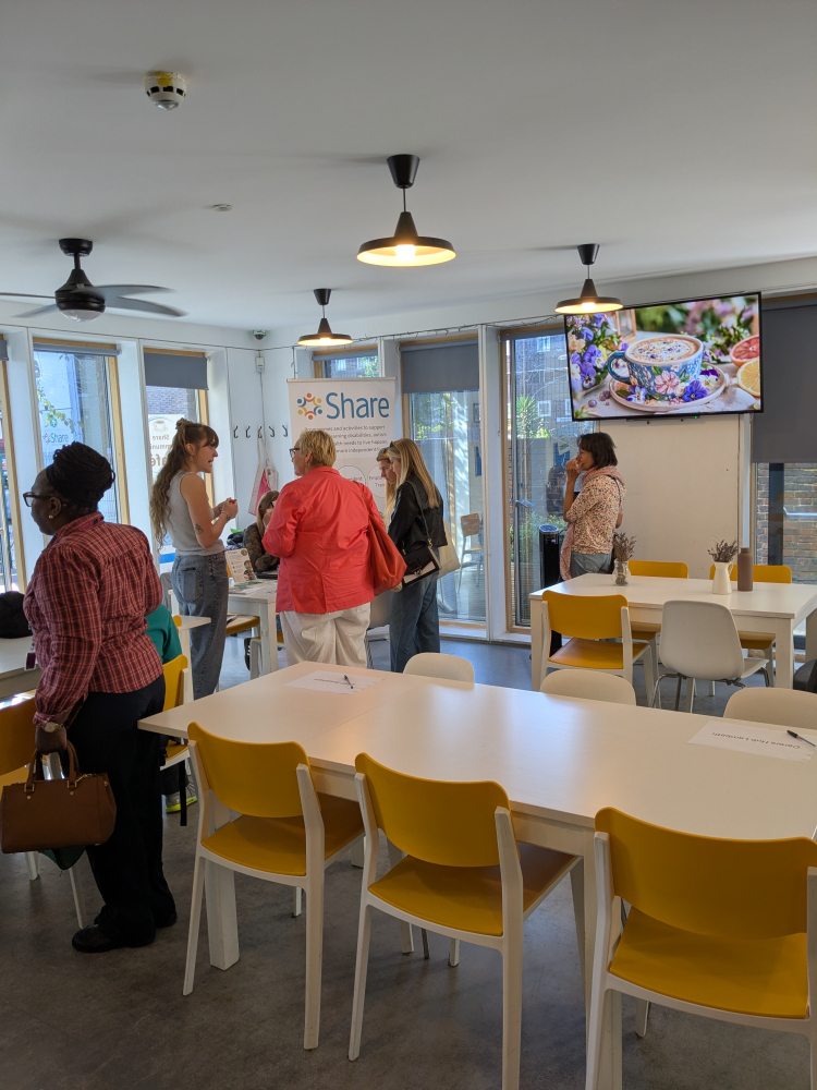 Groups of people stand around talking at the event, huddled around a tabletop
