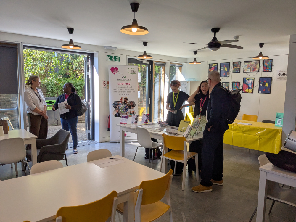 Groups of people stand around talking at the event, huddled around a tabletop