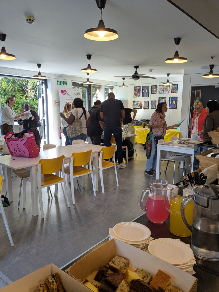 Groups of people stand around talking at the event, huddled around a tabletop