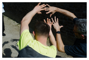 Arty photo of the back of someone's head who has their hands in the air to make shadows