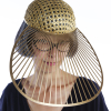Glamorous lady with fashionable gold headwear, peers out from under the meshed hat, she wears glasses