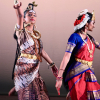 Two Indian dancers in traditional dress posing on stage