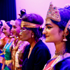 Group of professional Indian dancers stand in a line on stage together with a Share student