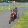 Man riding a recumbent trike on a track enjoying the sunshine