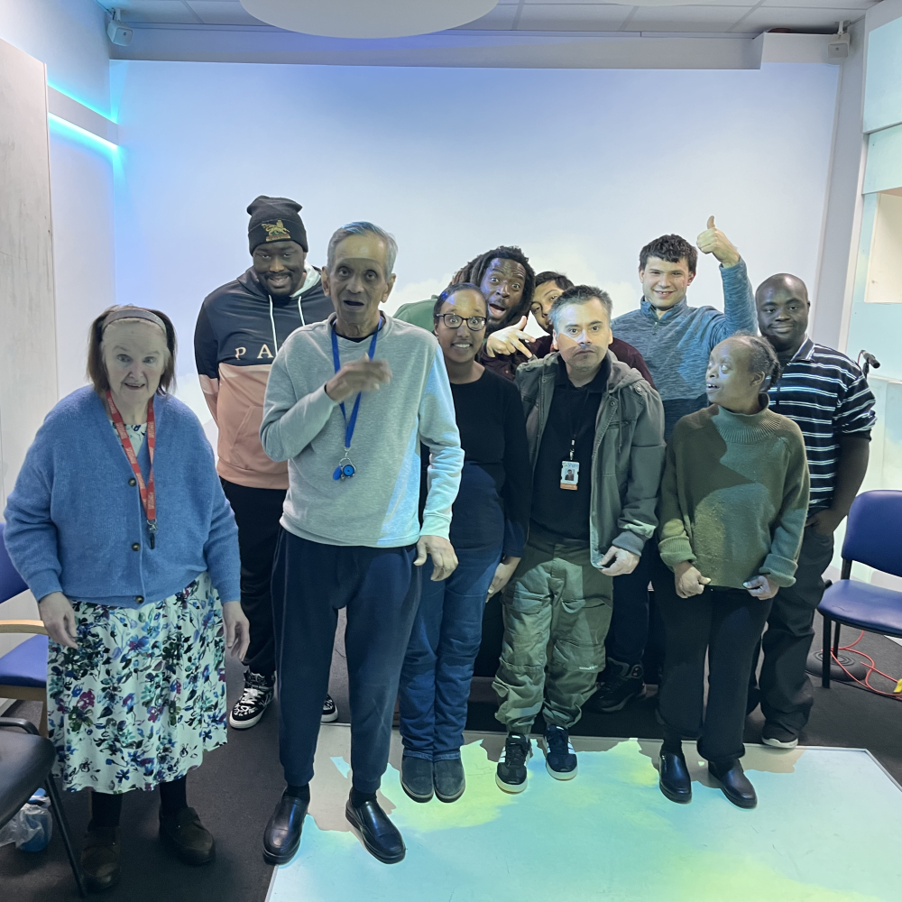 A group of Share students and composer Aga pose for the camera in a group shot in Share's music room