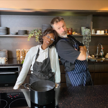Chef and student stand next to the work surface posing for the camera.