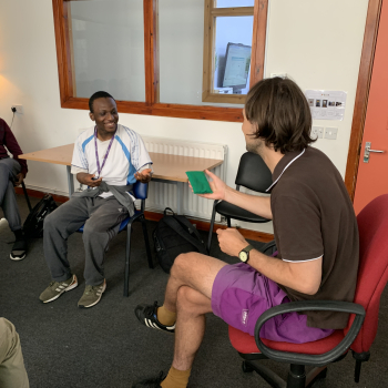 A tutor at Share is talking to students in class