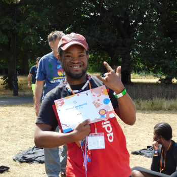 A man stands proudly with his gift certificate at sports day