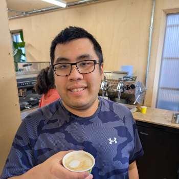 A man proudly shows off the barista style coffee he's just made